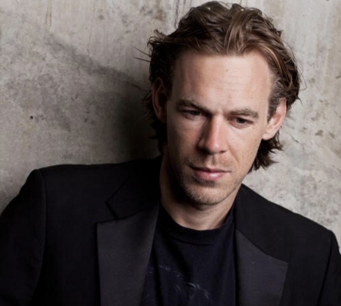 Professional headshot of British actor Tim Burke